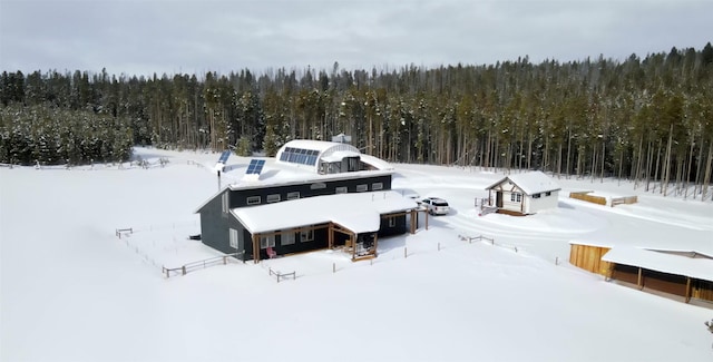 snowy aerial view featuring a forest view