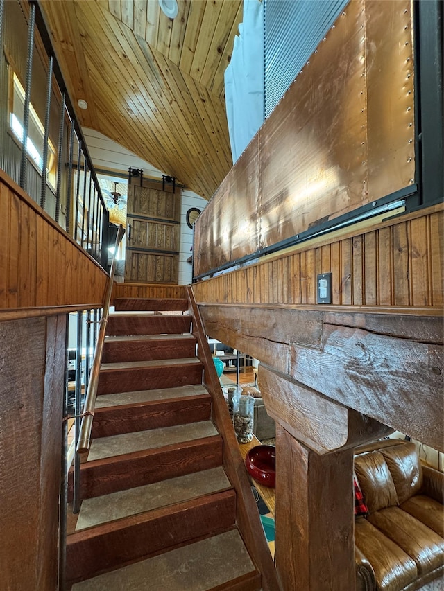 stairs with wooden ceiling, wooden walls, and vaulted ceiling