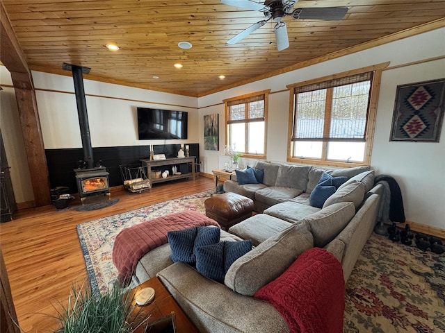 living room with wooden ceiling, a wood stove, a ceiling fan, and wood finished floors