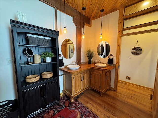 bathroom with wooden ceiling, wood finished floors, double vanity, and a sink