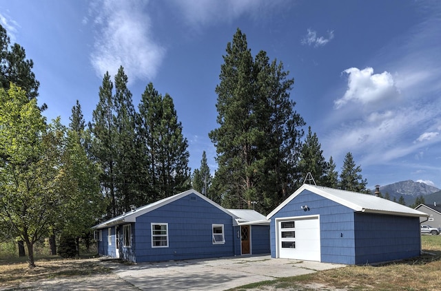 view of front of house featuring metal roof, an outbuilding, a garage, and driveway