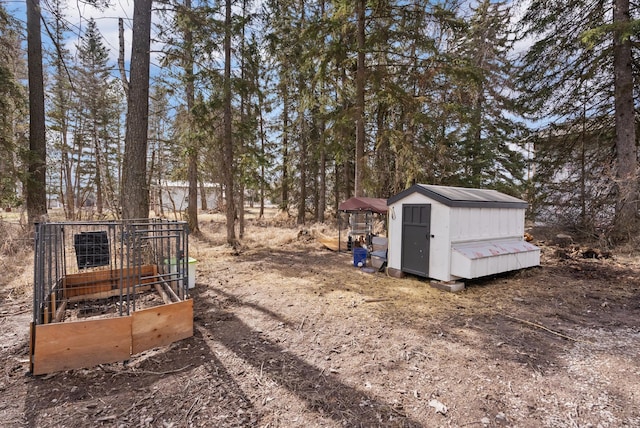 view of yard featuring a storage shed, an outdoor structure, and a garden