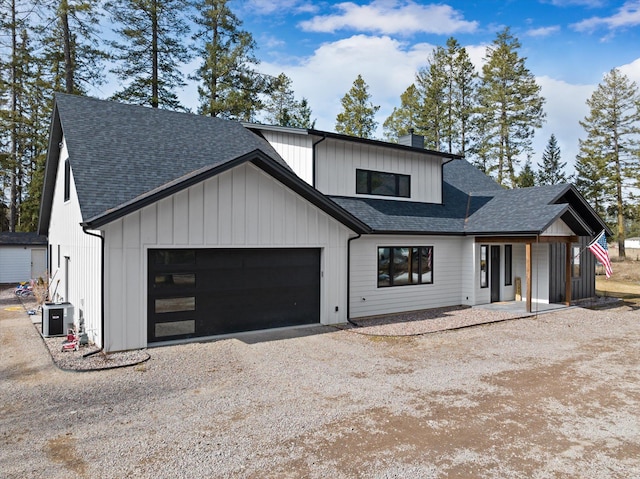 modern farmhouse style home with a chimney, a garage, driveway, and a shingled roof