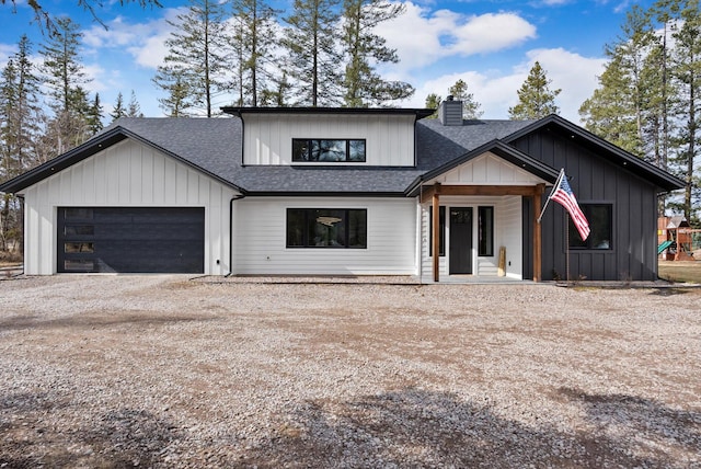 modern farmhouse style home with an attached garage, a chimney, a shingled roof, dirt driveway, and board and batten siding