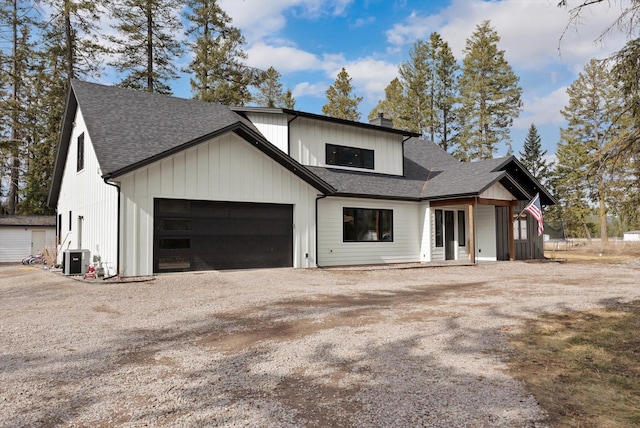 view of front of home featuring a garage, driveway, a chimney, and roof with shingles