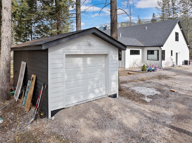 detached garage featuring central AC unit and driveway