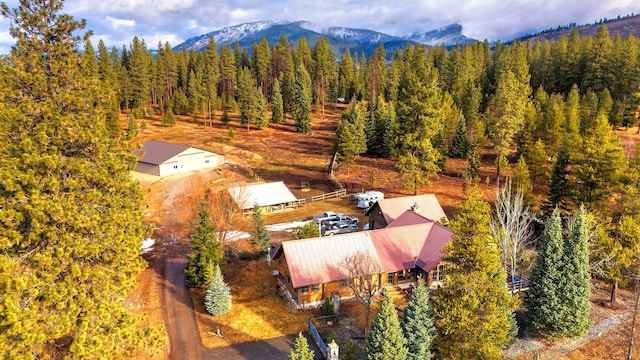 birds eye view of property featuring a mountain view and a wooded view