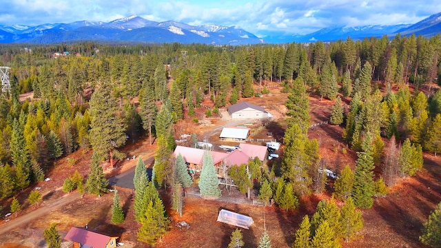 drone / aerial view featuring a mountain view and a view of trees