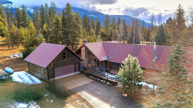 17 Mountain View Rd, Trout Creek, MT 59874 - view of front facade with a wooded view, a chimney, a metal roof, a mountain view, and a garage