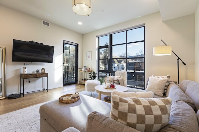 living room featuring recessed lighting, visible vents, baseboards, and light wood-style floors