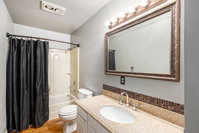 full bath with vanity, toilet, wood finished floors, and shower / bath combo with shower curtain