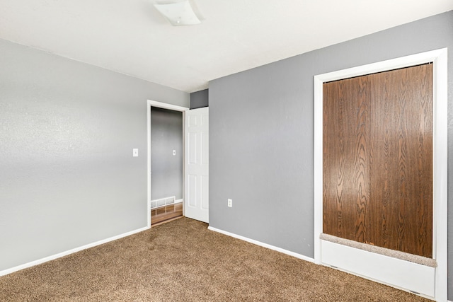 unfurnished bedroom featuring visible vents, baseboards, a closet, and carpet flooring