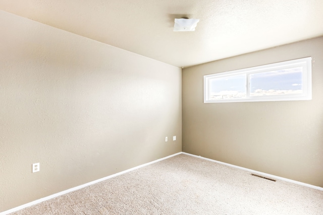 unfurnished room with carpet flooring, visible vents, and baseboards