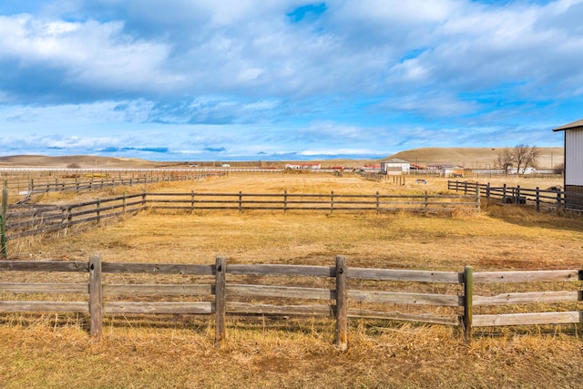 view of yard with a rural view and fence