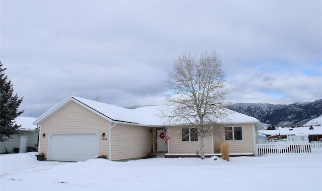 ranch-style home featuring a garage and fence