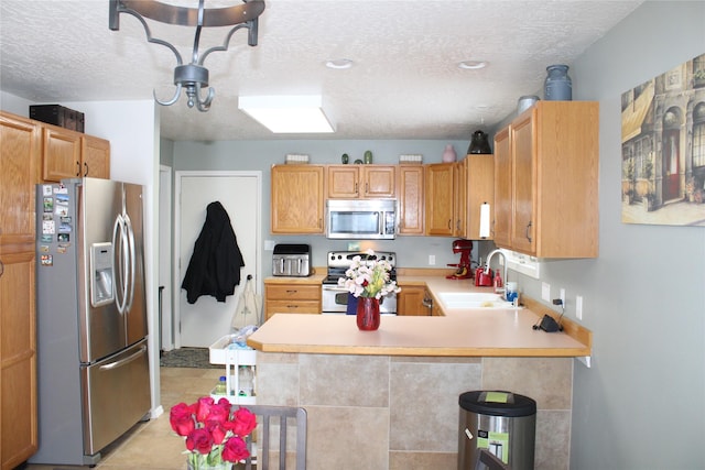 3004 Green Cir, Butte, MT 59701 - kitchen with stainless steel appliances, a sink, light countertops, a peninsula, and a textured ceiling