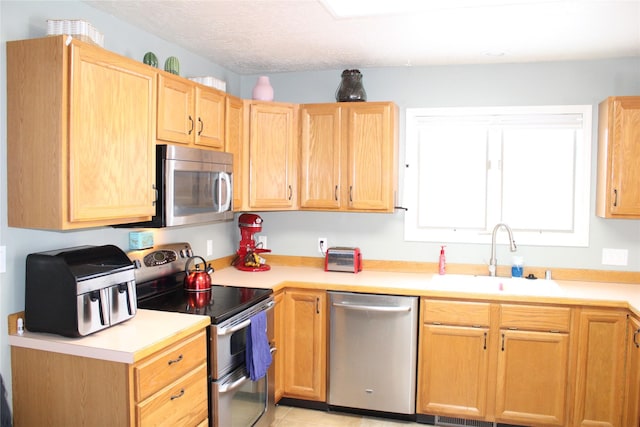 3004 Green Cir, Butte, MT 59701 - kitchen featuring appliances with stainless steel finishes, a sink, light countertops, and light brown cabinetry