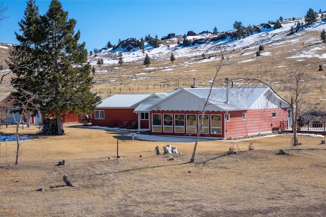 back of house featuring metal roof