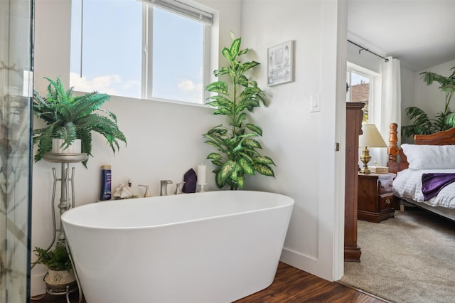 full bathroom with a soaking tub, ensuite bath, baseboards, and wood finished floors