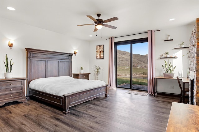 bedroom with access to exterior, dark wood-style floors, recessed lighting, and a mountain view