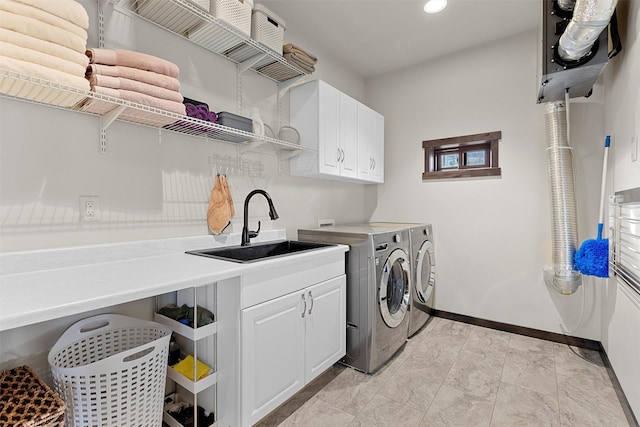 washroom featuring baseboards, recessed lighting, washer and dryer, cabinet space, and a sink