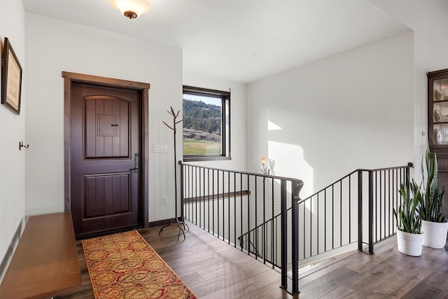 foyer entrance with wood finished floors and baseboards