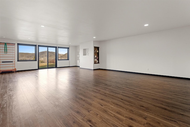 unfurnished living room featuring recessed lighting, baseboards, and dark wood-style floors