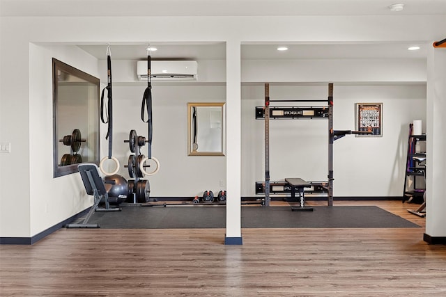 workout room with recessed lighting, a wall mounted air conditioner, baseboards, and wood finished floors