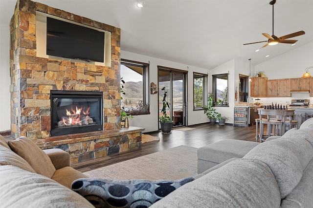 living area with high vaulted ceiling, a ceiling fan, dark wood-style floors, and a fireplace