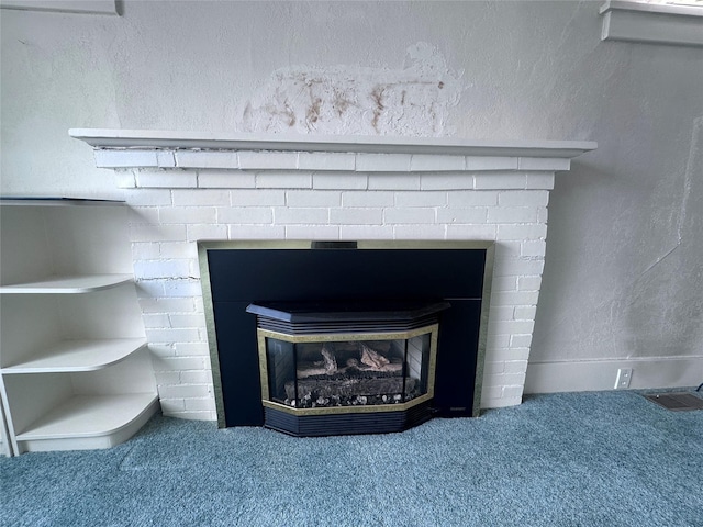 room details featuring visible vents, carpet floors, a fireplace, and a textured wall