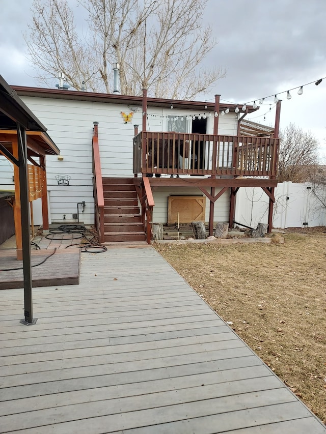 back of property featuring a deck, stairs, and fence