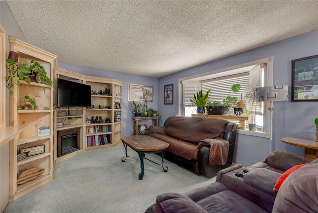 carpeted living room with a glass covered fireplace and a textured ceiling