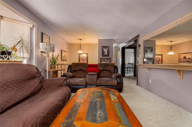 living room featuring carpet, a chandelier, and a textured ceiling