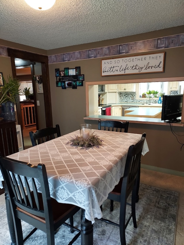 dining area featuring a textured ceiling and a healthy amount of sunlight