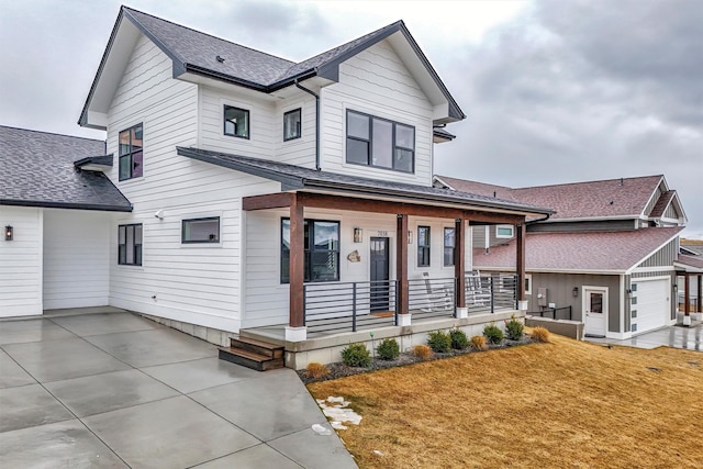 view of front facade featuring a porch, a front yard, and roof with shingles