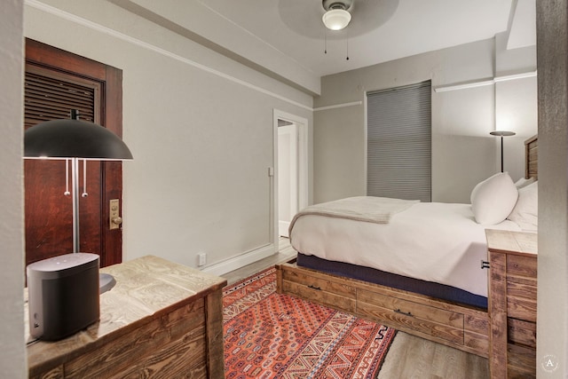 bedroom featuring ceiling fan, baseboards, and wood finished floors