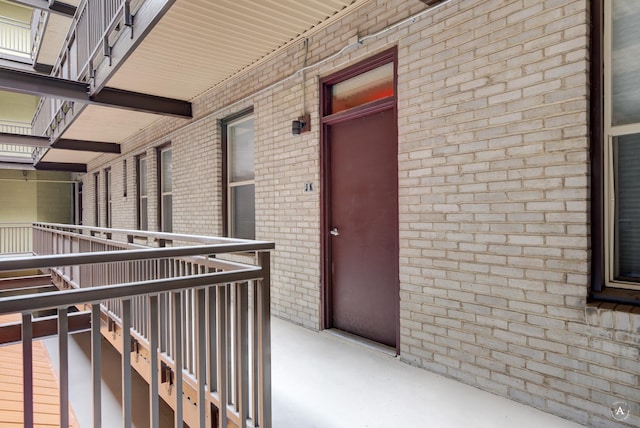 view of exterior entry featuring brick siding