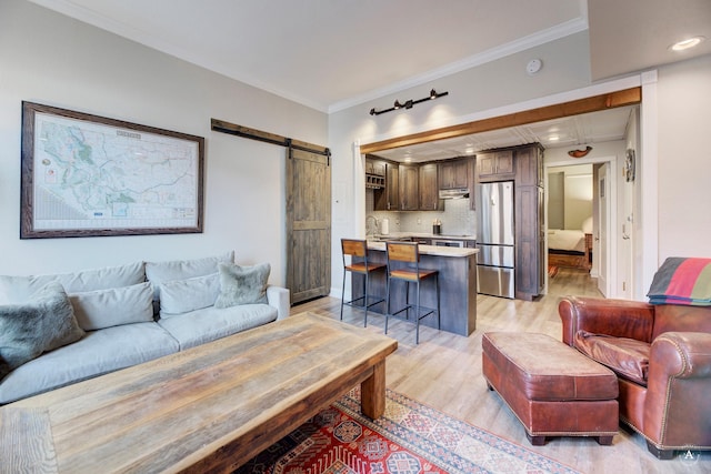 living area featuring recessed lighting, light wood-style flooring, a barn door, and ornamental molding