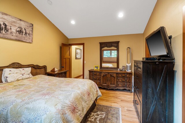 bedroom with vaulted ceiling, light wood-style flooring, and recessed lighting