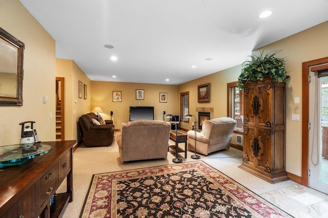 living room with visible vents, recessed lighting, a warm lit fireplace, and baseboards