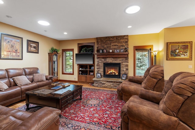 living area with a fireplace, wood finished floors, recessed lighting, and a healthy amount of sunlight