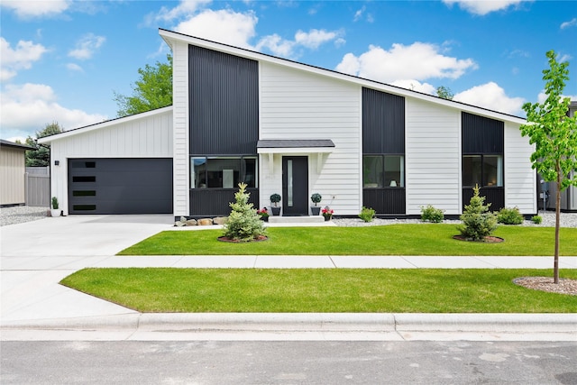 view of front of house featuring a front lawn, an attached garage, and driveway