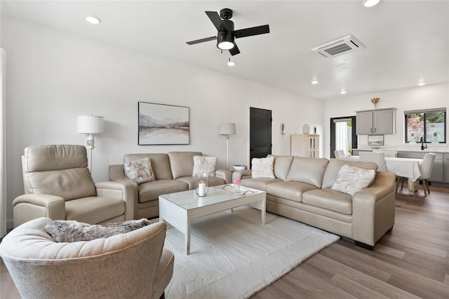 living room with visible vents, recessed lighting, a ceiling fan, and light wood-style floors