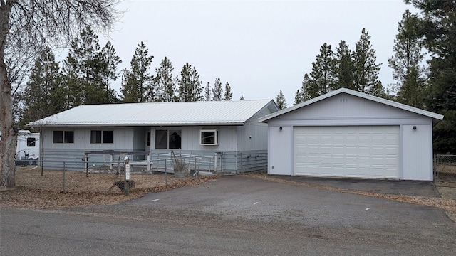 ranch-style house with an outbuilding, metal roof, and fence