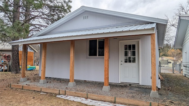 exterior space with an outbuilding, metal roof, and fence