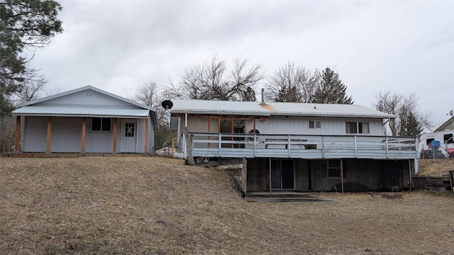 back of property with metal roof and a deck