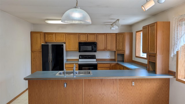 kitchen featuring a sink, brown cabinets, black appliances, and a peninsula