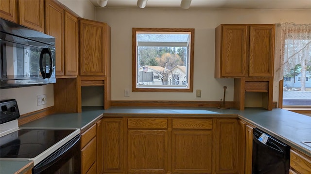 kitchen with a ceiling fan, black appliances, brown cabinetry, and light countertops