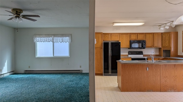 kitchen featuring open floor plan, baseboard heating, brown cabinets, black appliances, and a sink