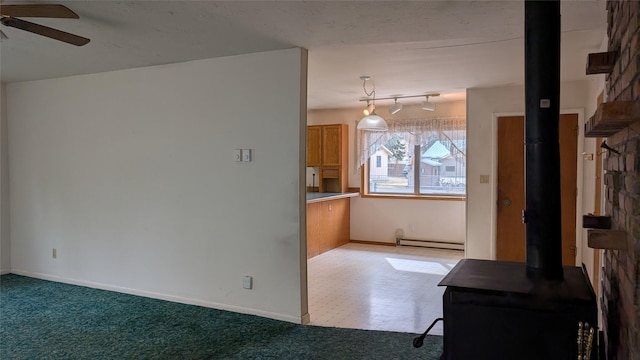 interior space with a baseboard radiator, baseboards, carpet floors, and a ceiling fan